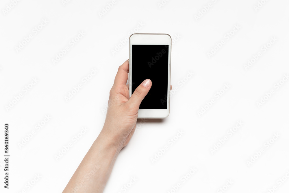 Close up of human hands using smartphone isolated on white background. Top view. Copyspace, blank screen. Surfing, online shopping, scrolling, betting, working. Education and business concept. Close up of human hands using smartphone isolated on white background. Top view. Copyspace, blank screen. Surfing, online shopping, scrolling, betting, working. Education and business concept.