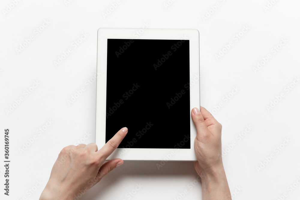 Close up of human hands using tablet isolated on white background. Top view. Copyspace, blank screen. Surfing, online shopping, scrolling, betting, working. Education and business concept. Close up of human hands using tablet isolated on white background. Top view. Copyspace, blank screen. Surfing, online shopping, scrolling, betting, working. Education and business concept.