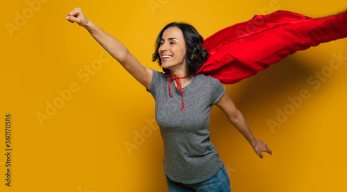 Картината върху платно I am coming to you! A half-length photo of a young, beautiful girl, pretending she is a superwoman, and flying in a classic superman pose, because she is flying to help someone