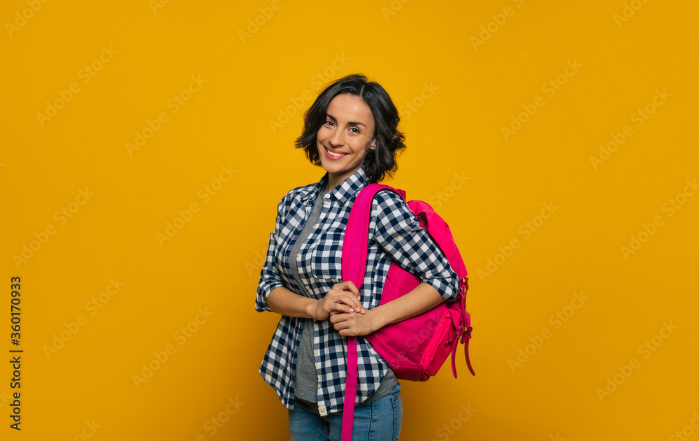  I am gonna be a great student! A half-length photo of a young student, dressed casually, smiling widely at the camera, holding her cute pink backpack on her one shoulder, ready to meet her day.