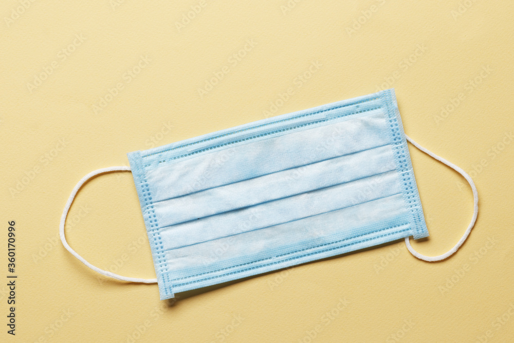 Surgical mask with rubber ear straps. Typical 3-ply surgical mask to cover the mouth and nose. Procedure mask from bacteria. Protection concept.