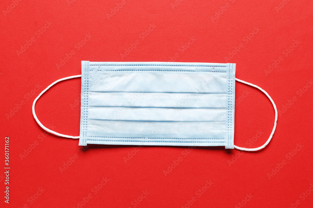 Surgical mask with rubber ear straps. Typical 3-ply surgical mask to cover the mouth and nose. Procedure mask from bacteria. Protection concept. Surgical mask with rubber ear straps. Typical 3-ply surgical mask to cover the mouth and nose. Procedure mask from bacteria. Protection concept.