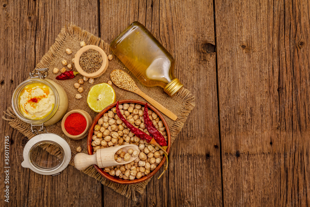 Hummus on old wooden boards background. Dry chickpea, olive oil, lemon, cumin and chili pepper Hummus on old wooden boards background. Dry chickpea, olive oil, lemon, cumin and chili pepper