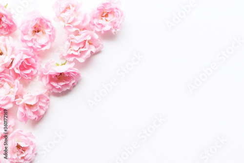 Styled stock photo. Spring feminine scene, floral composition. Decorative banner, corner made of beautiful pink roses. White table background. Flat lay, top view. © avoferten