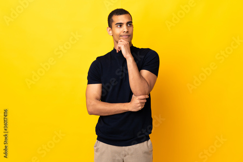 African American man over isolated background thinking an idea while looking up