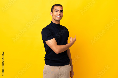 African American man over isolated background pointing back