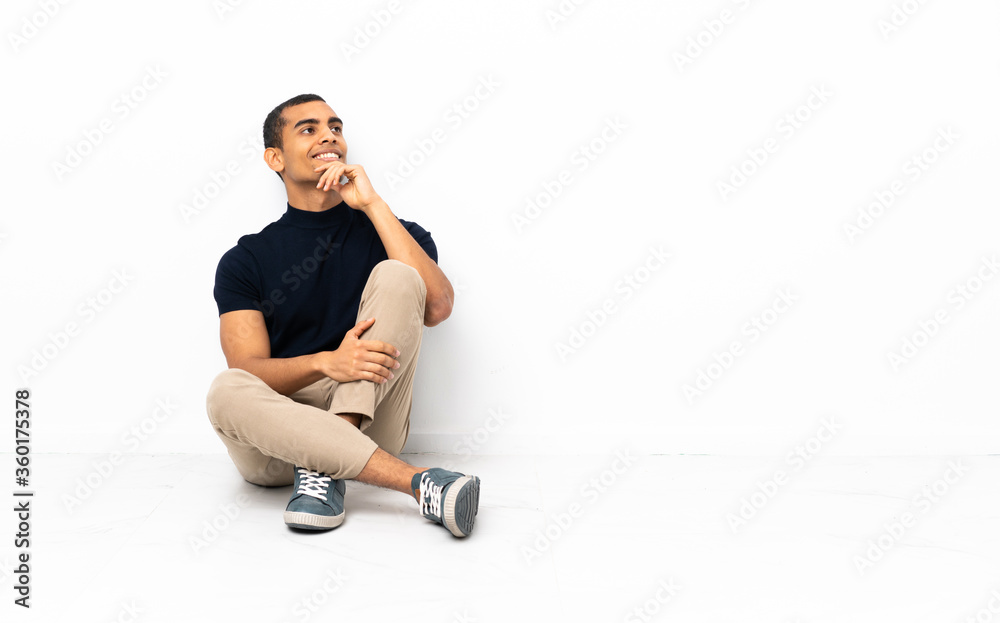 Fototapeta premium African American man sitting on the floor looking to the side