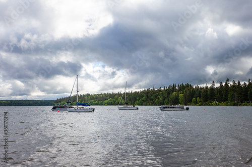 Boats on the water in Clear Lake in Wasagaming, Manitoba during a cloudy day photo