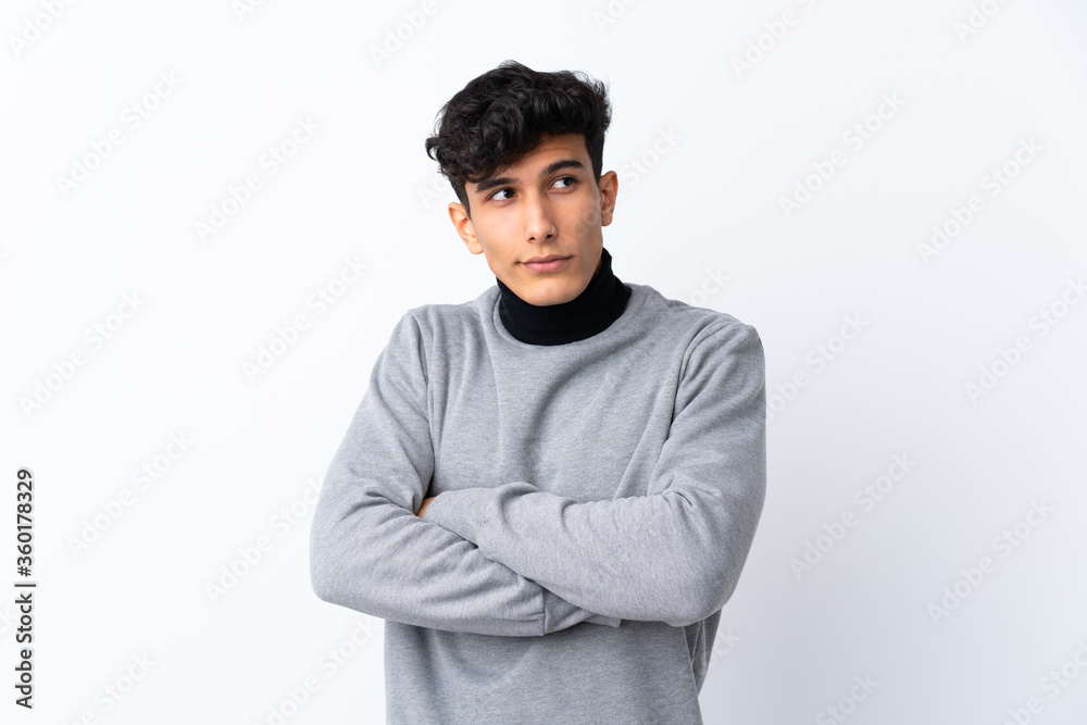 Young Argentinian man over isolated white background making doubts gesture while lifting the shoulders Young Argentinian man over isolated white background making doubts gesture while lifting the shoulders