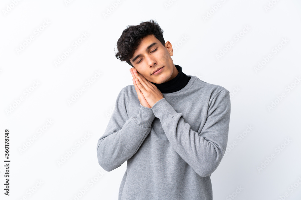 Young Argentinian man over isolated white background making sleep gesture in dorable expression Young Argentinian man over isolated white background making sleep gesture in dorable expression