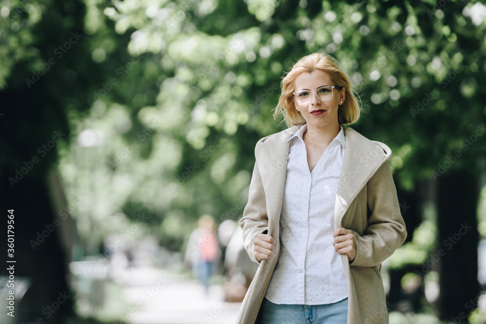 young blonde woman smiling outdoors