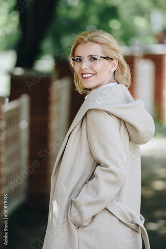 young blonde woman smiling outdoors