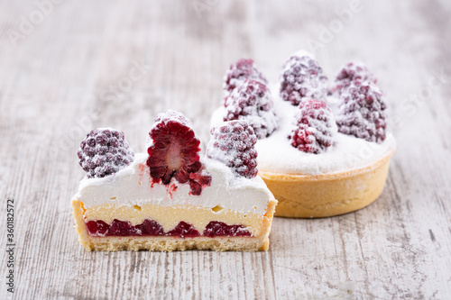 Sand dough with cranberry confitur, custard and whipped cream with fresh berries photo