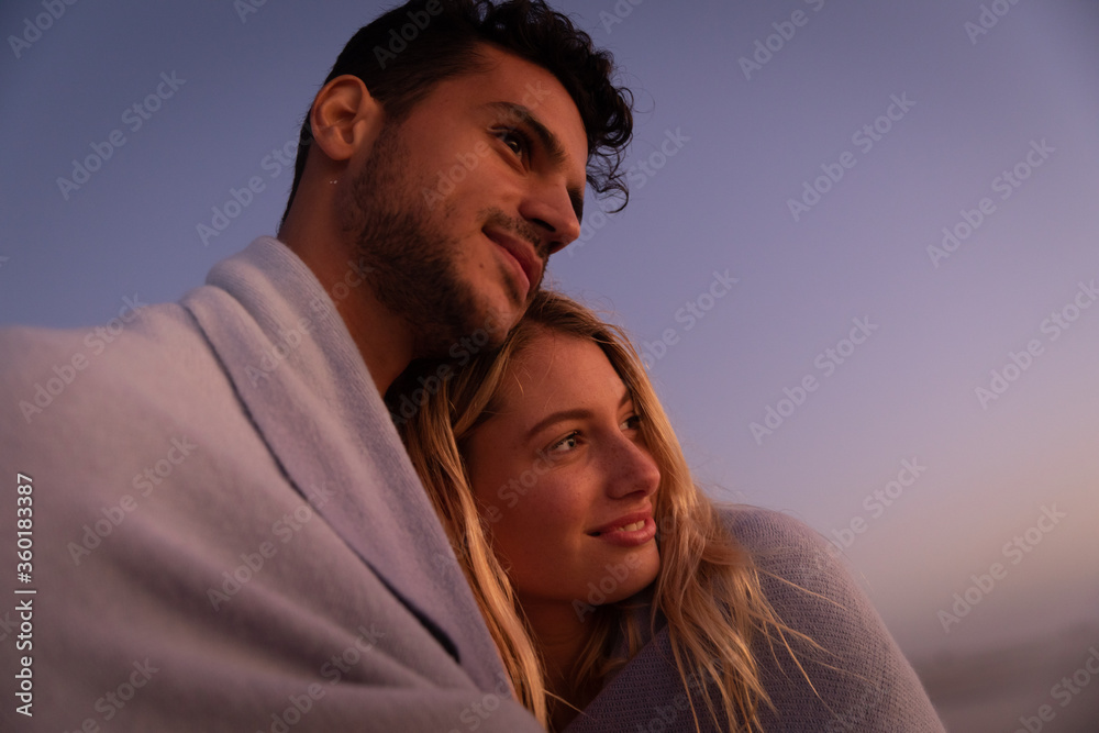 Caucasian couple enjoying time at the beach during the sunset