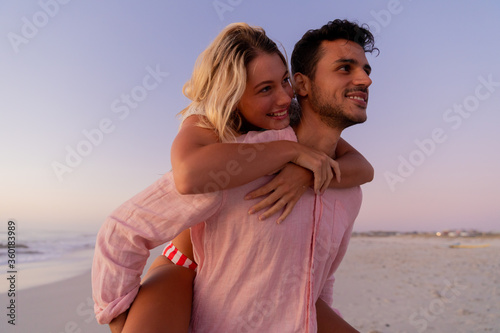 Caucasian couple enjoying time at the beach during the sunset