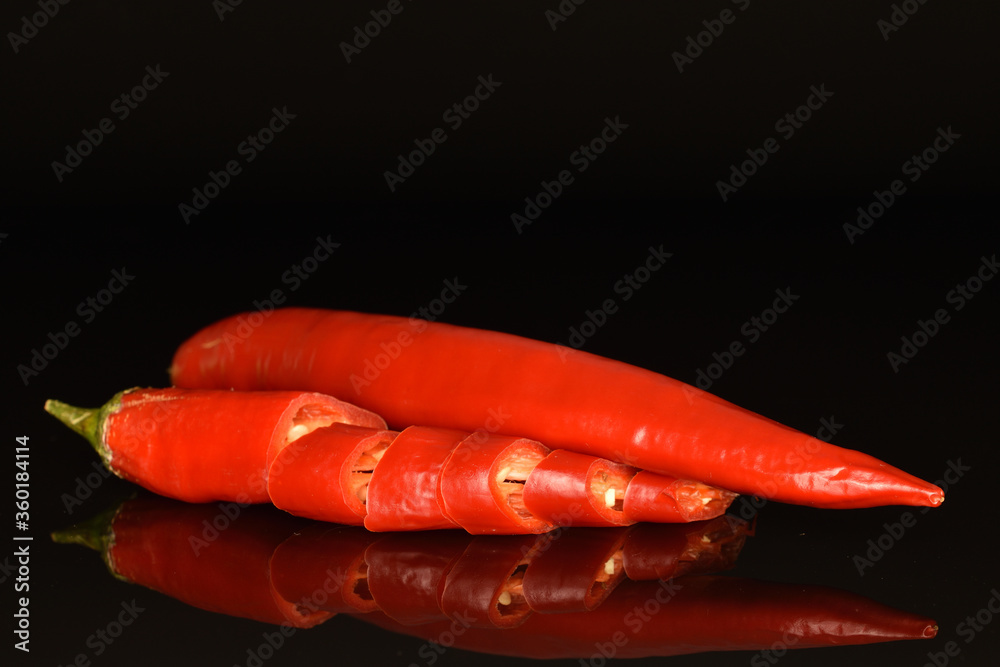 Red chili peppers, close-up, on a black background. Red chili peppers, close-up, on a black background.