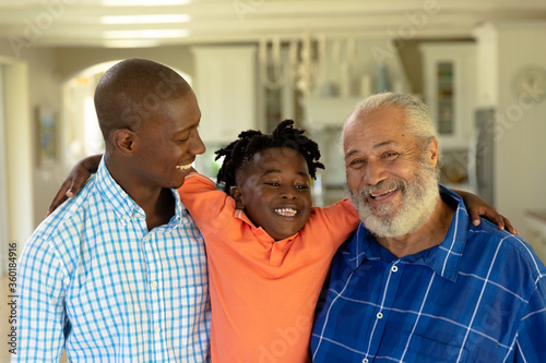 African American man standing with his senior father and his young son