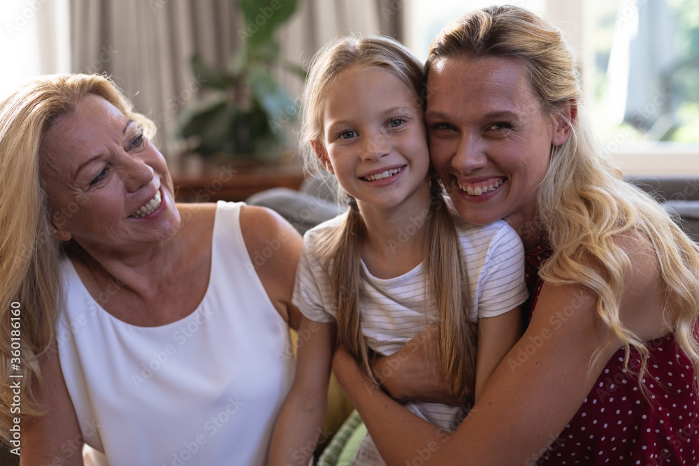Caucasian woman with her daughter and mother sitting on a couch Caucasian woman with her daughter and mother sitting on a couch