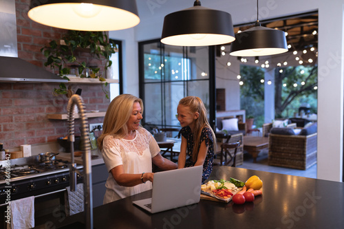 Senior caucasian woman spending time in the kitchen with her granddaughter photo