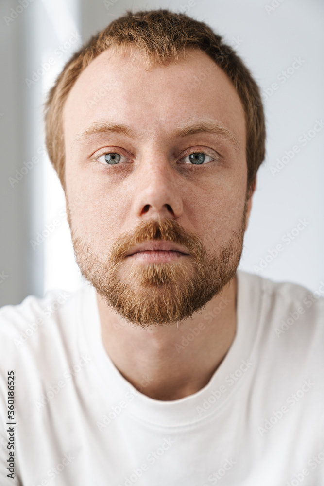 Photo closeup of serious young man posing and looking on camera Photo closeup of serious young man posing and looking on camera