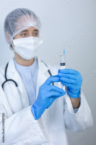 Healthcare worker holding a vaccine wearing face mask during coronavirus Covid19 pandemic
