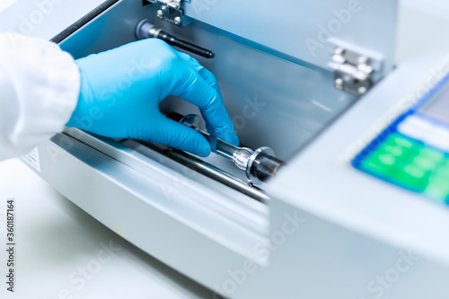 Analyst is placing the sample solution for test of specific rotation by automatic polarimeter in the laboratory, concept of chemical laboratory in pharmaceutical industry, selective focus photograph.