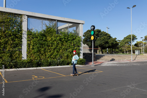 Caucasian woman wearing a portective mask and skating in the streets