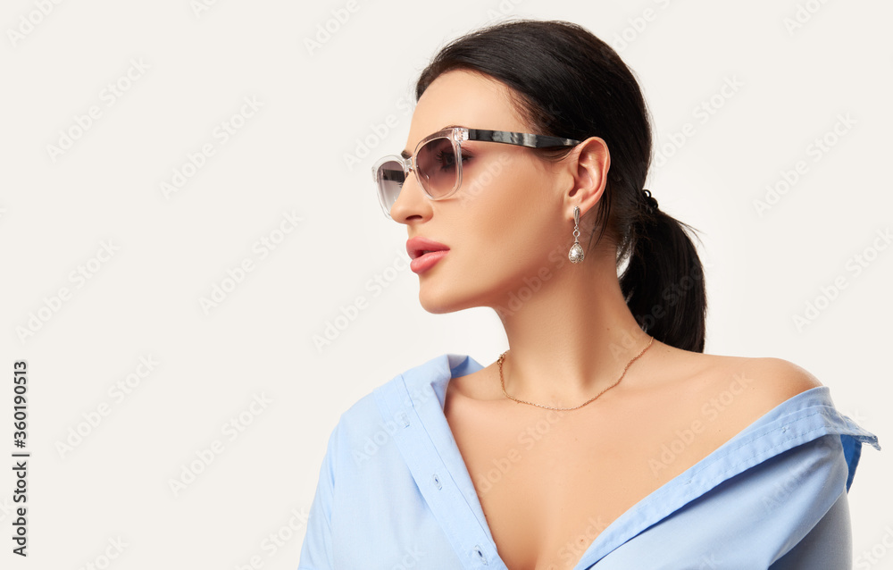 Advertising of possible and modern optics and lenses. Beautiful woman in trendy sunglasses posing over white background. portrait of stylish caucasian female model Advertising of possible and modern optics and lenses. Beautiful woman in trendy sunglasses posing over white background. portrait of stylish caucasian female model