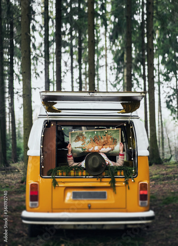 Traveler girl sitting in the retro car looking map.