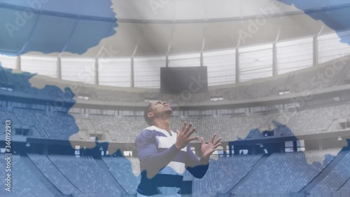 Animation of Antarctican flag waving over mixed race male rugby player catching a ball  photo
