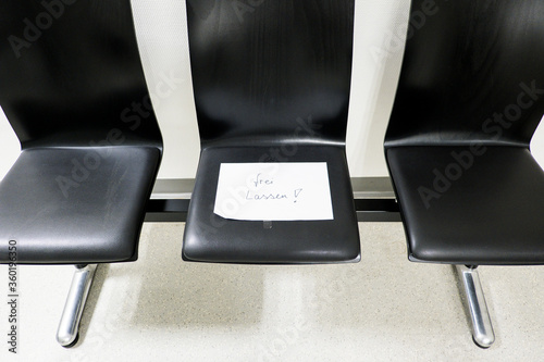 Sitzreihe mit handschriftlichen Zettel auf dem frei lassen steht als Abstandsregel in der Coronakrise photo