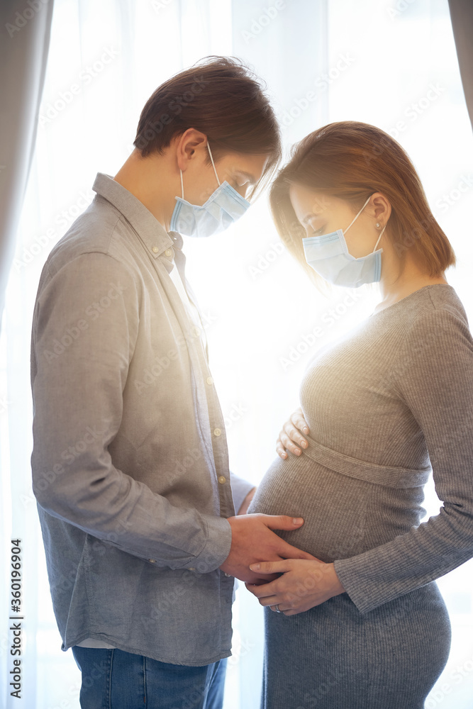 Fototapeta premium Sunny day at home of pregnant young couple in quarantine