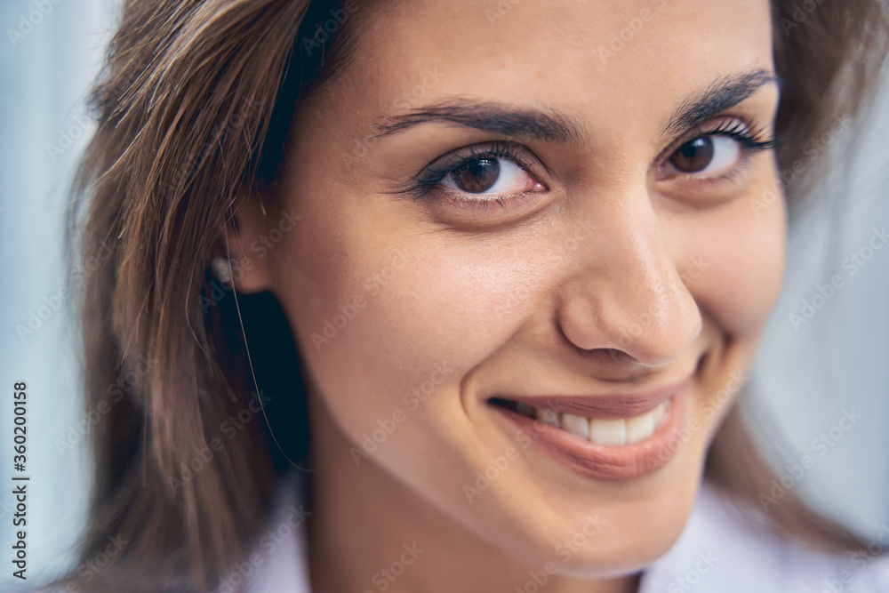 Charming young woman looking at camera and smiling Charming young woman looking at camera and smiling