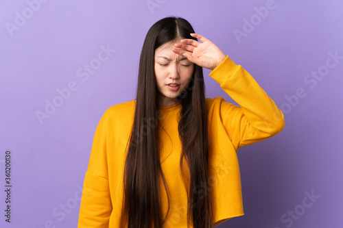 Young Chinese girl over isolated purple background with tired and sick expression © luismolinero