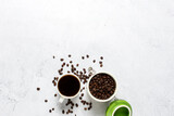 cup with coffee, a can of coffee beans and coffee beans are scattered on a concrete background. Banner. Concept of fresh coffee, breakfast, plantation. Top view, flat lay
