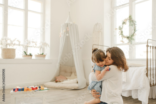 A young mother spends time with her little daughter at home.