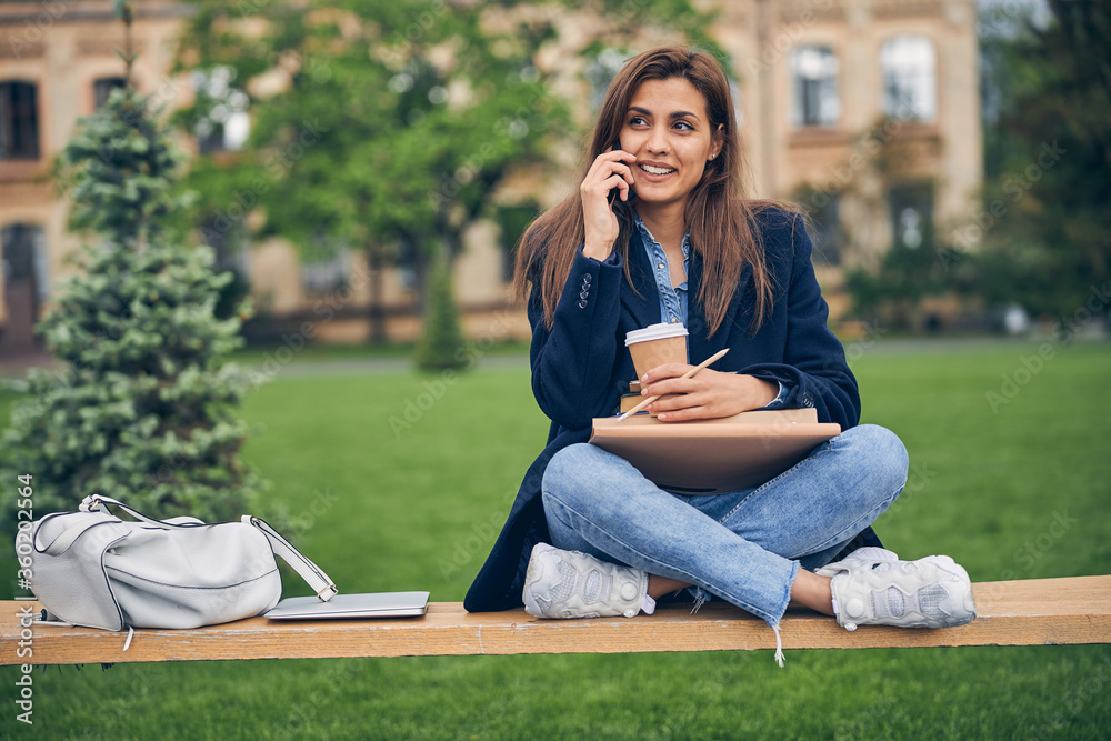 Beautiful student lady speaking on mobile outside Beautiful student lady speaking on mobile outside