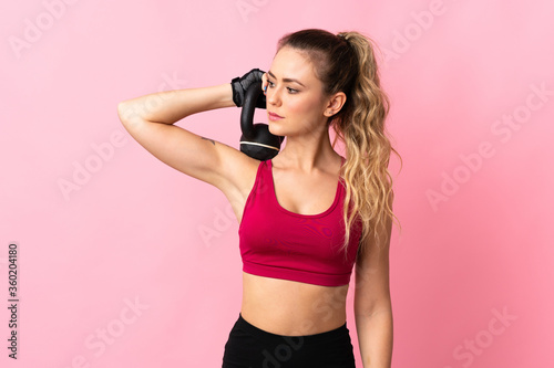 Fototapeta Naklejka Na Ścianę i Meble -  Young Brazilian woman isolated on pink background making weightlifting with kettlebell
