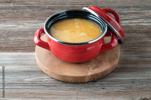 homemade red lentils soup in a saucepan on a wooden table photo