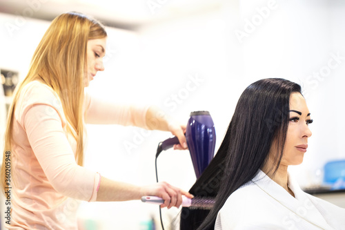 Beautiful woman with black hair at hairdresser