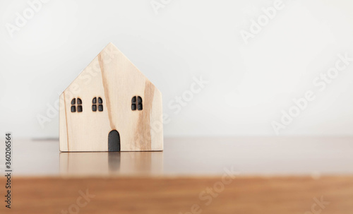 Wooden house model on wooden table with copy space. Home, housing, insurance and real estate concept.