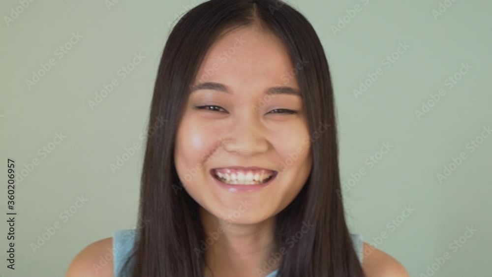 portrait close-up. cute asian girl looking at the camera and laughing joyfully 4K portrait close-up. cute asian girl looking at the camera and laughing joyfully 4K