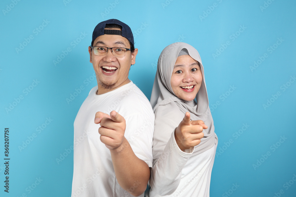Happy Asian Muslim Couple Smiling and Pointing to Camera