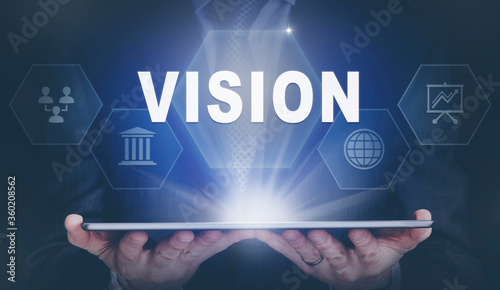 Businessman holding a computer tablet display projecting a Vision concept.