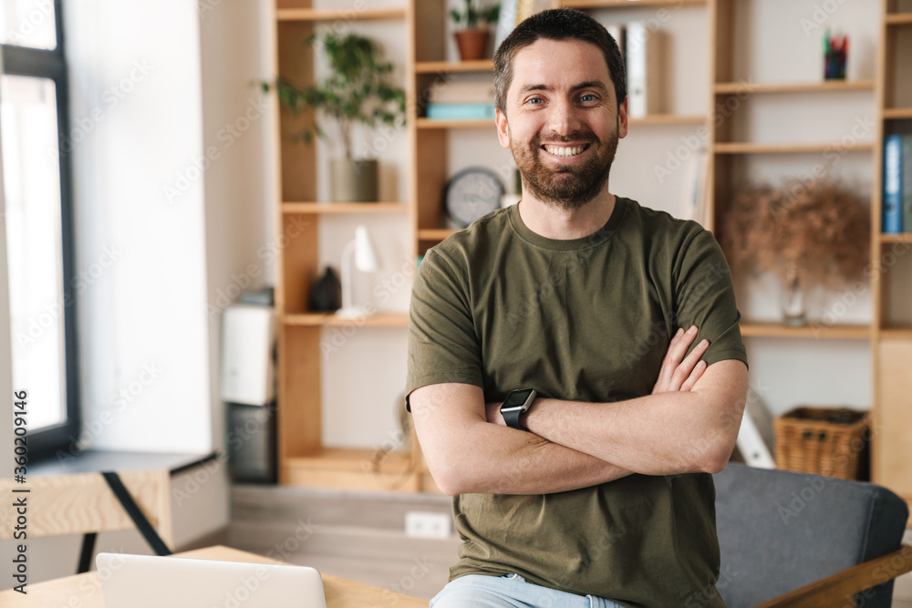 Fototapeta premium Photo of cheerful handsome man smiling and looking at camera