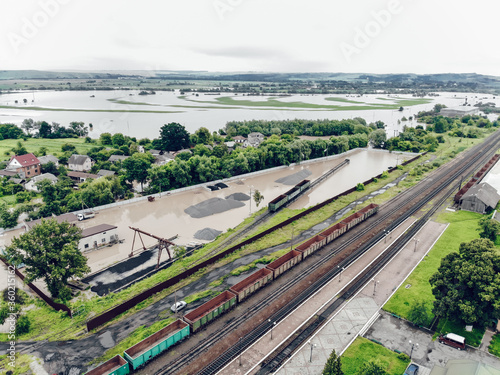 View of the railway track and the flooded village. Natural disaster in Ukraine. Roads, streets and houses are flooded with dirty water photo