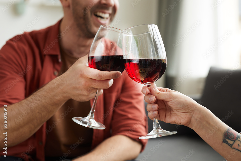 Close-up of man toasting with glass of wine with woman during their date