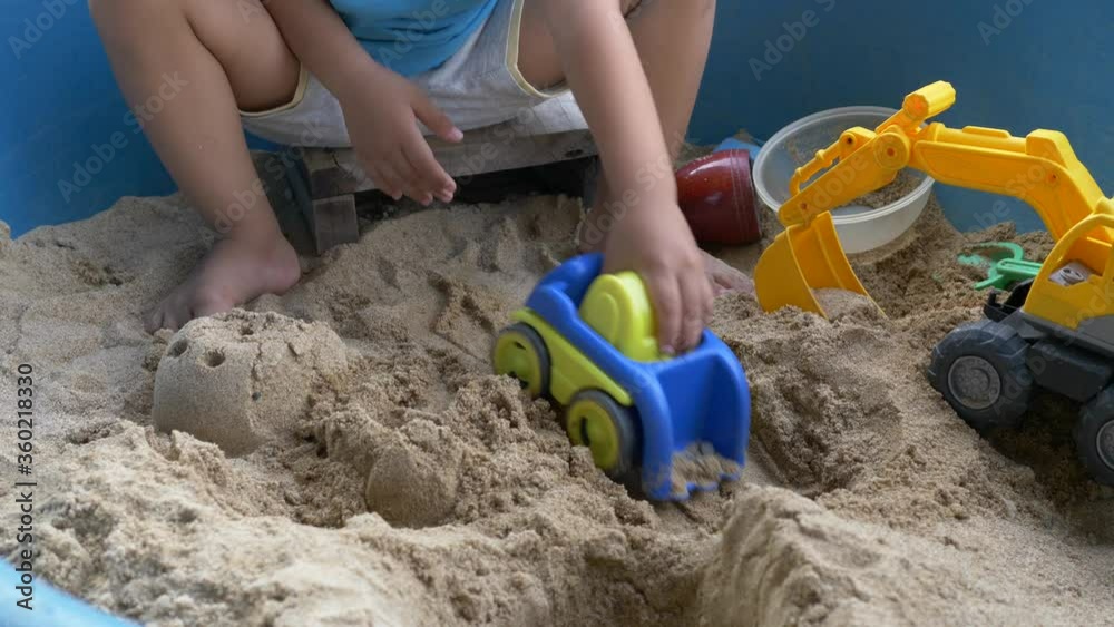 4K Hand of asian child boy playing car truck toy and sand in sandbox with happy time outdoor. Family relax and freedom time in summer holiday. 4K Hand of asian child boy playing car truck toy and sand in sandbox with happy time outdoor. Family relax and freedom time in summer holiday.