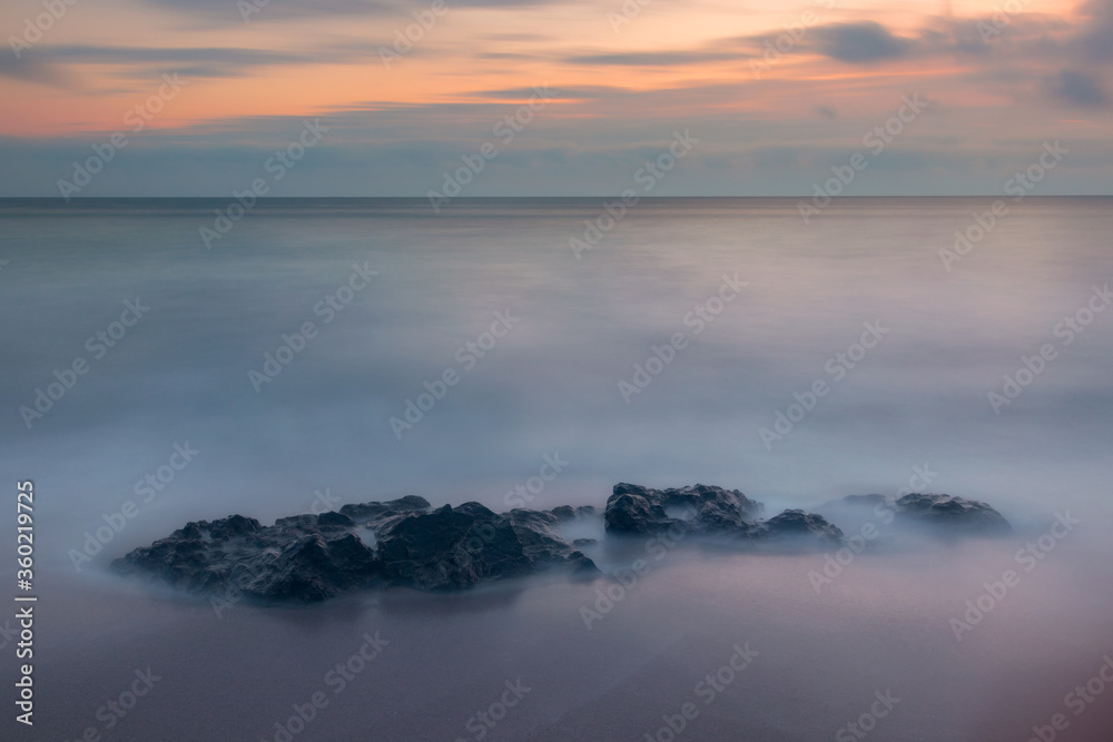 Minimalistic seascape with sea and stone in the water