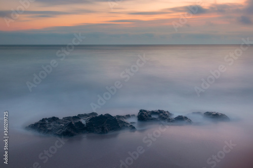 Minimalistic seascape with sea and stone in the water